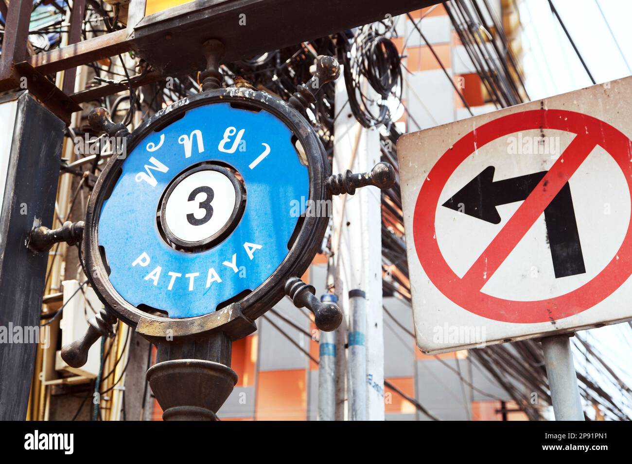 Straßenschild PATTAYA 3 auf Englisch und Thailändisch neben einem SCHILD OHNE LINKSABBIEGEN. Stockfoto