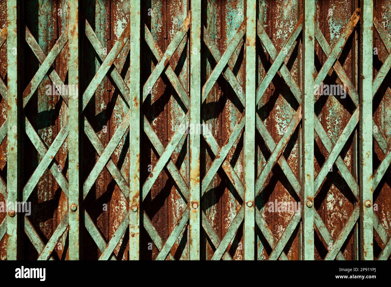 Blaugrüne Farbe alten rostigen Falten gate Hintergrund. Grüne geometrische Muster Gitter zum Store Eingang. Geschlossen asiatischen Shop detail Stockfoto