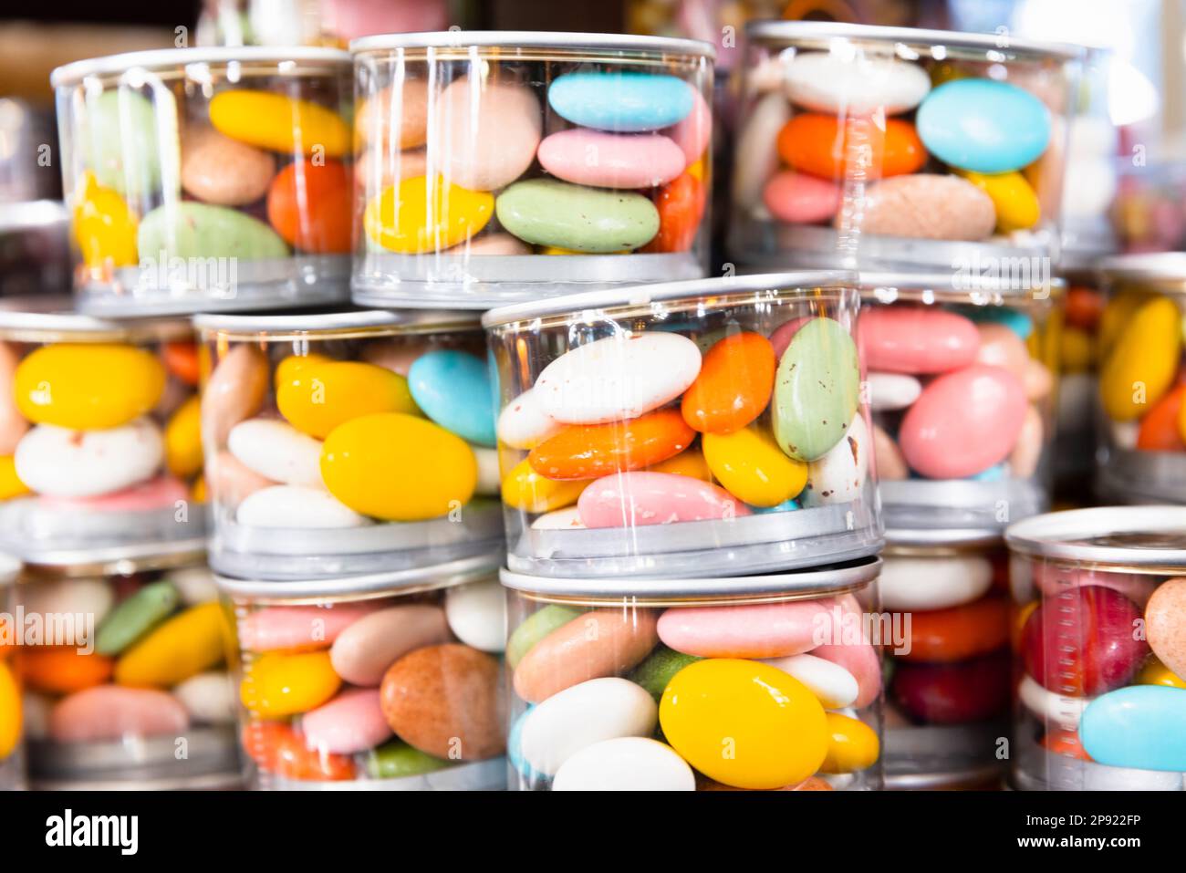 Dragee Candies in gestapelten transparenten Kunststoffbechern. Hintergrundfoto des Süßigkeitenladens Stockfoto