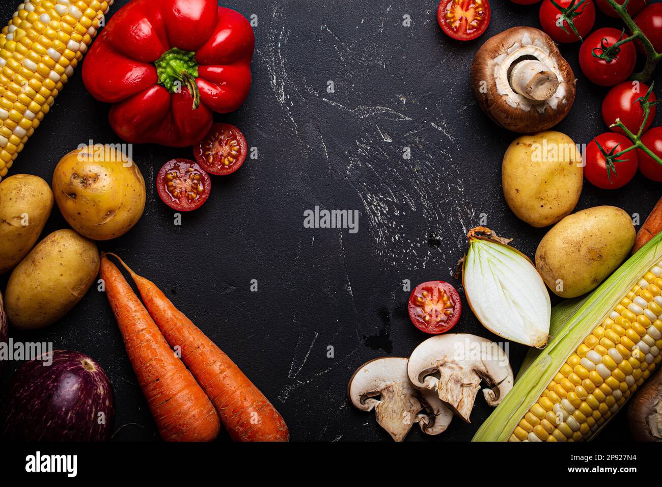 Hintergrund der Kochkunst mit Zutaten, gemischtes rohes, rohes, ungekochtes Gemüse auf schwarzem dunklem Steinhintergrund von oben Stockfoto