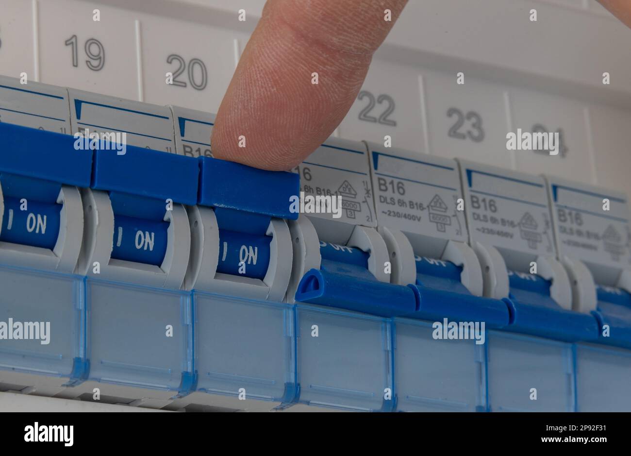 Der Techniker schaltet mehrere Sicherungen in einem Sicherungskasten eines Privathauses aus. Stockfoto