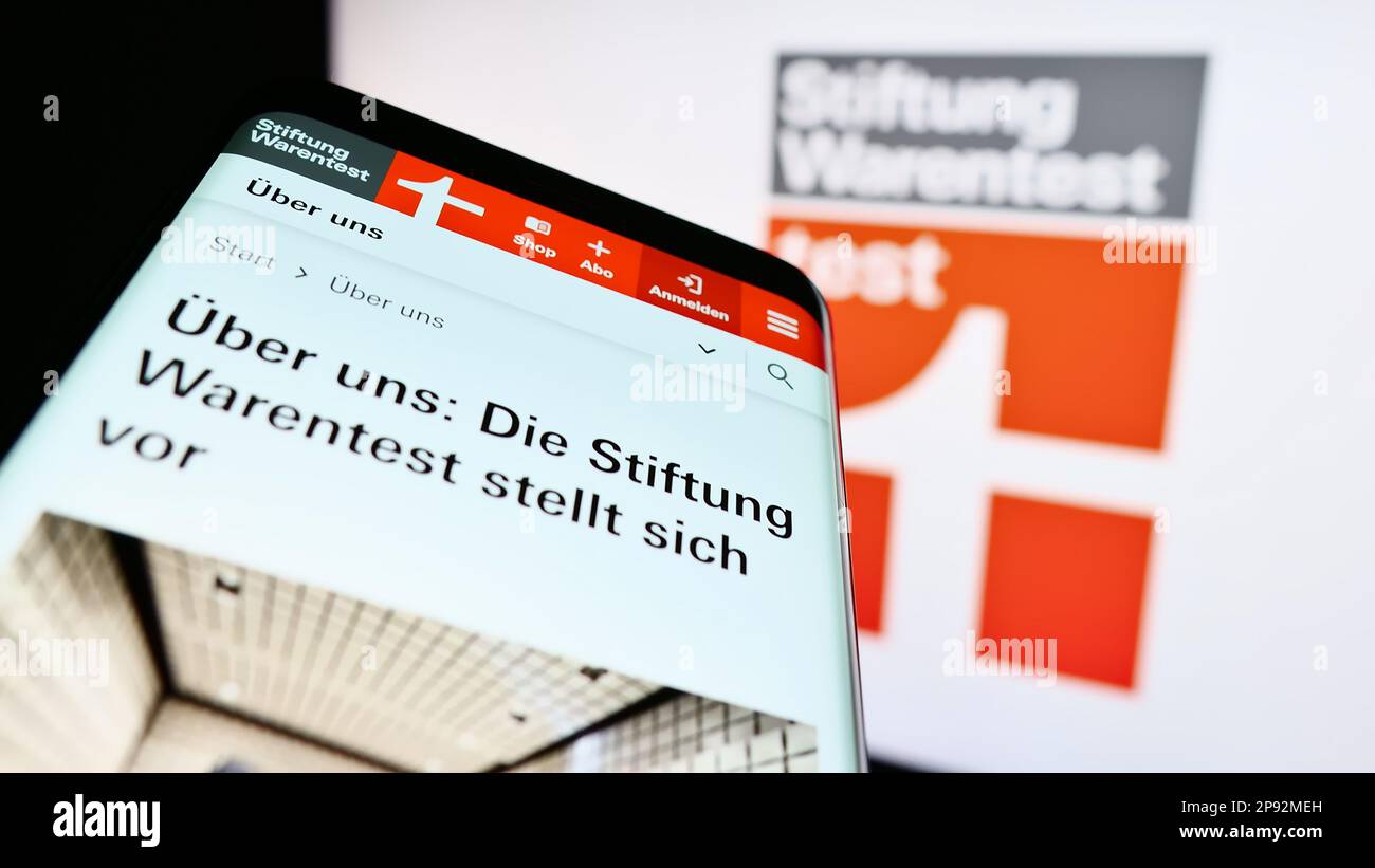 Mobiltelefon mit Website der Deutschen Verbraucherorganisation Warentest auf dem Bildschirm vor dem Logo. Fokus auf oberer linker Seite des Telefondisplays. Stockfoto