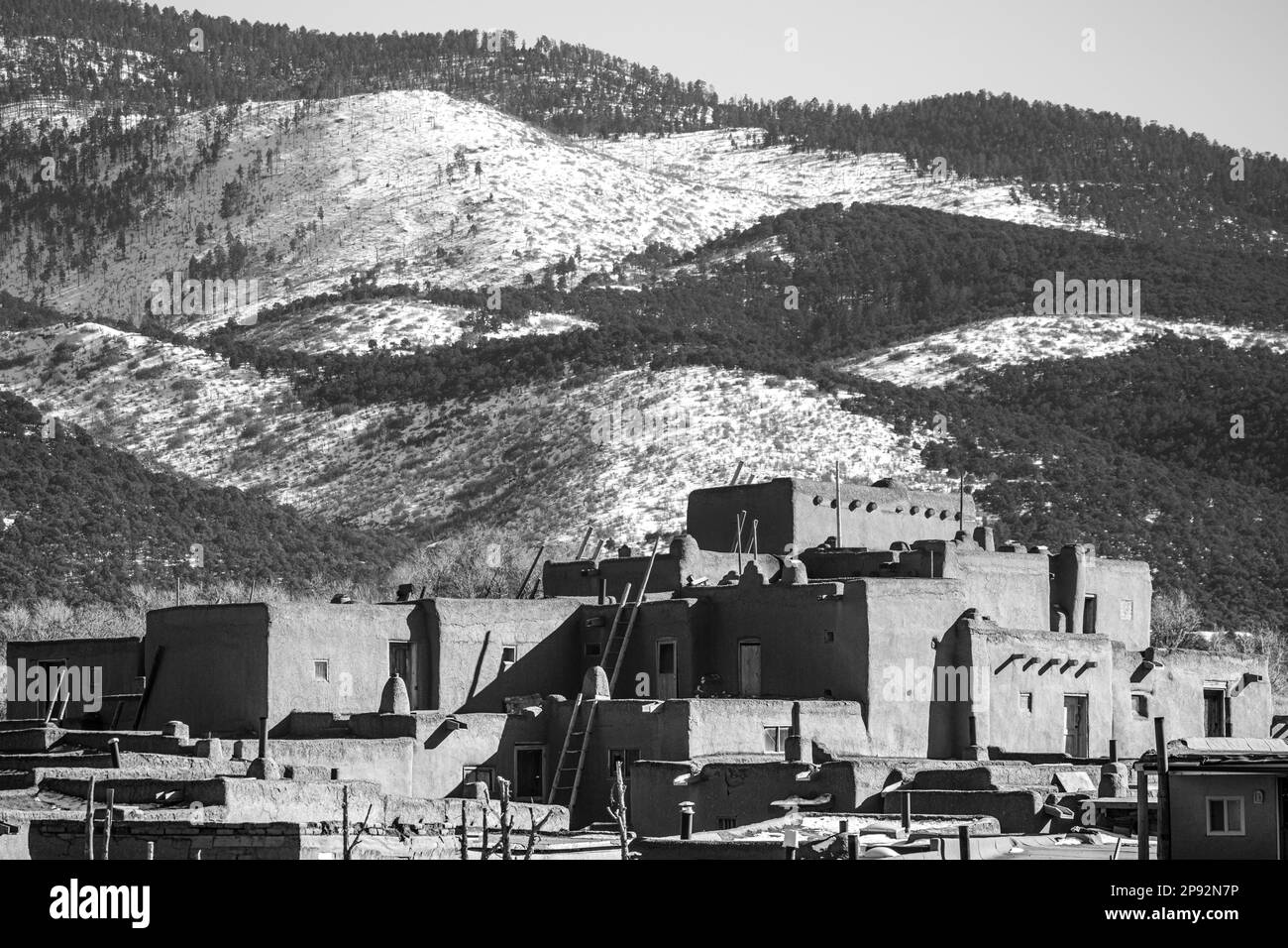 Eine ländliche Landschaft mit einer kleinen Ansammlung von Häusern, eingebettet in ein üppiges grünes Tal, New Mexico Pueblo Stockfoto