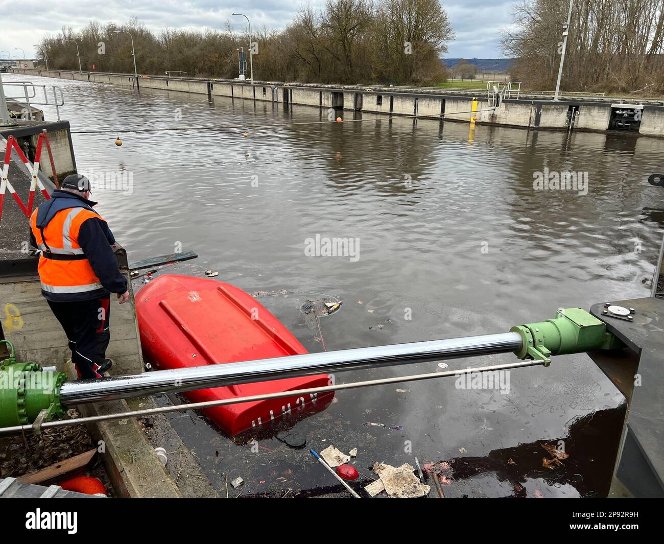 10. März 2023, Bayern, Wörth an der Donau: Ein gekentertes Boot liegt in der Geisling-Schleuse, wo zuvor ein etwa 80 Meter langes und mit Eisenerz beladenes Frachtschiff in der Donau gesunken war. Zwei Personen an Bord wurden nach ersten Berichten unverletzt, aber als Vorsichtsmaßnahme ins Krankenhaus gebracht. Die Ursache für den Untergang des Schiffes blieb zunächst unklar. Foto: Armin Weigel/dpa Stockfoto