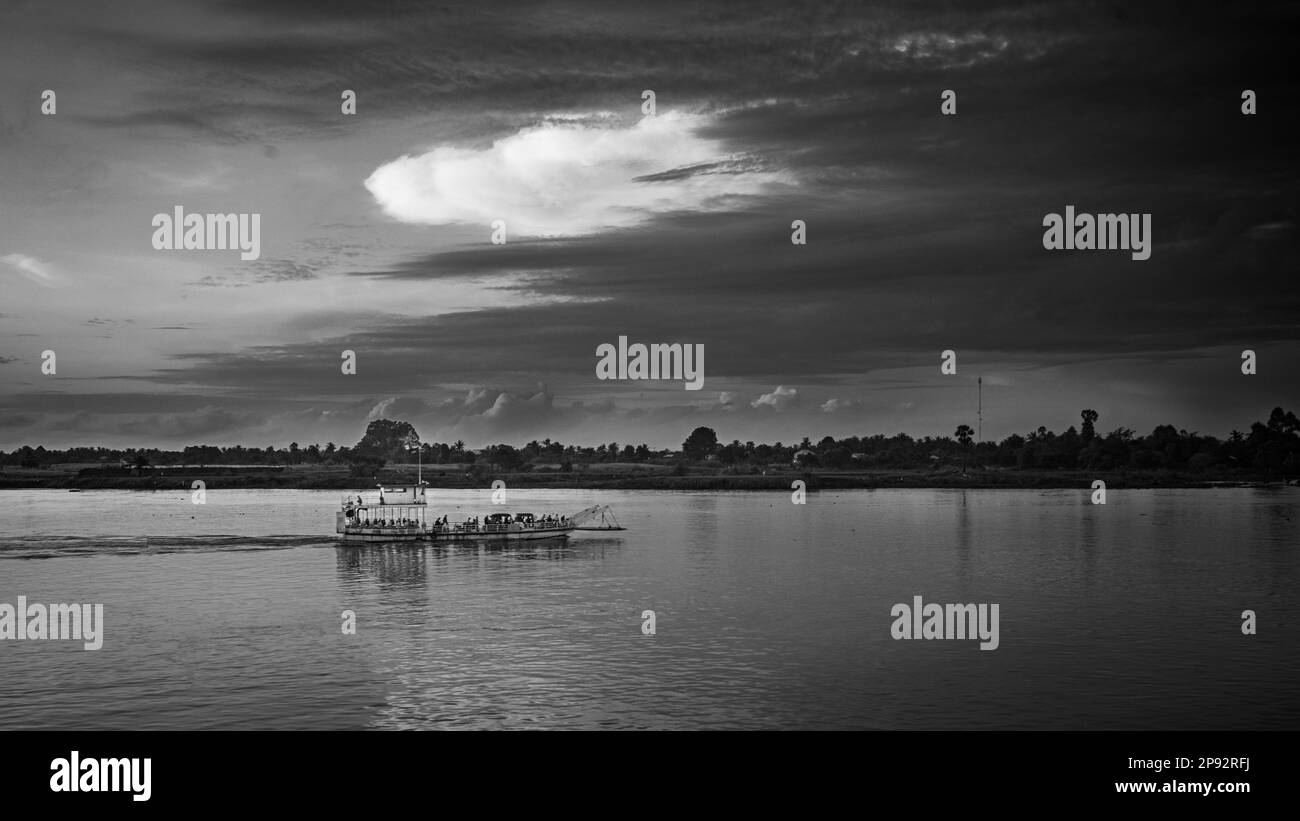 Eine kleine Fähre fährt bei Sonnenaufgang flussabwärts von Phnom Penh in Kambodscha über den Mekong. Stockfoto