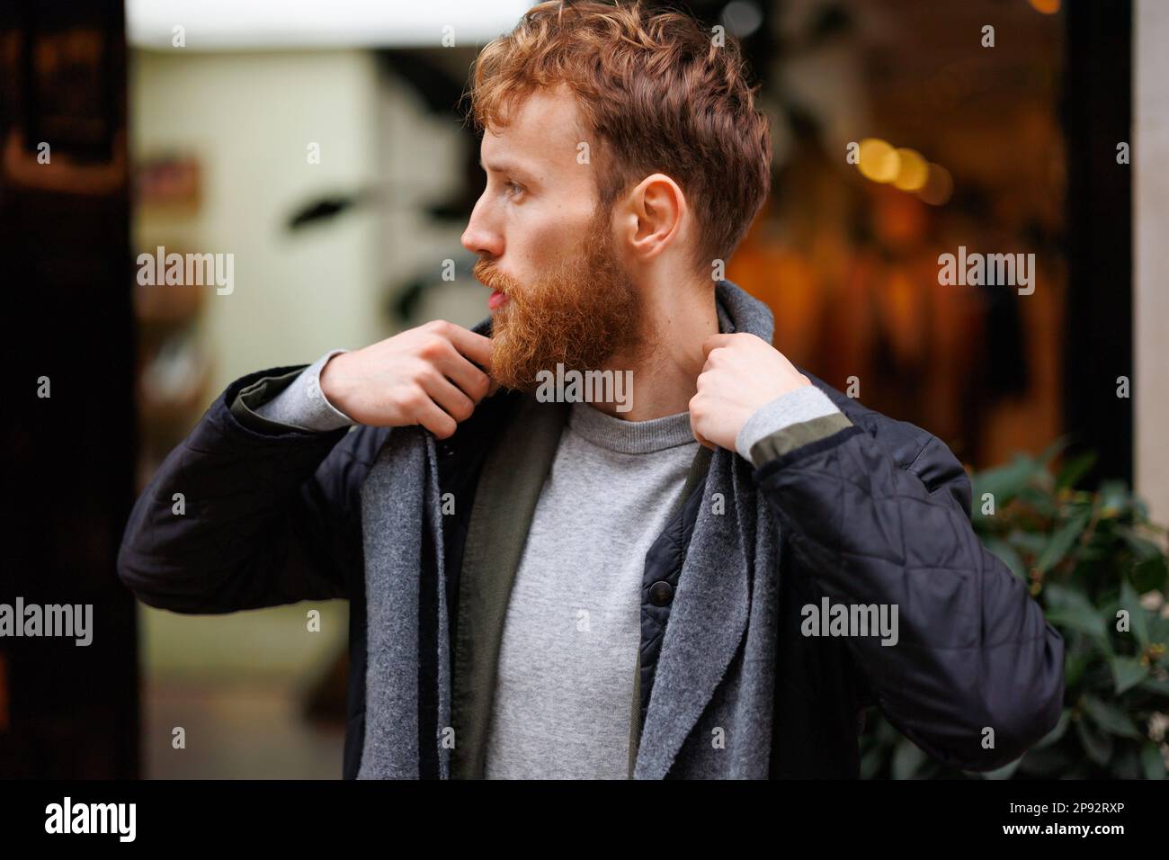 Porträt eines stilvoll gekleideten bärtigen Mannes, der sich draußen postet Stockfoto