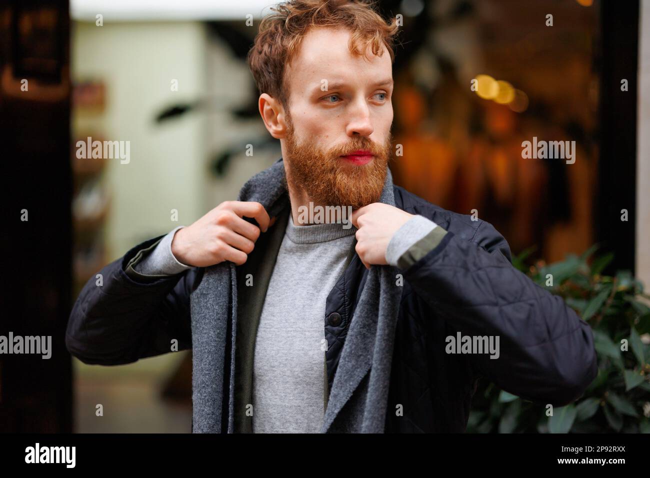 Porträt eines stilvoll gekleideten bärtigen Mannes, der sich draußen postet Stockfoto