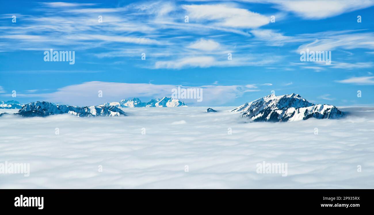 Schneebedeckte Berglandschaft über Wolken an einem sonnigen Wintertag. Allgäu-Alpen, im Hintergrund Säntis. Bayern, Deutschland, Schweiz Stockfoto