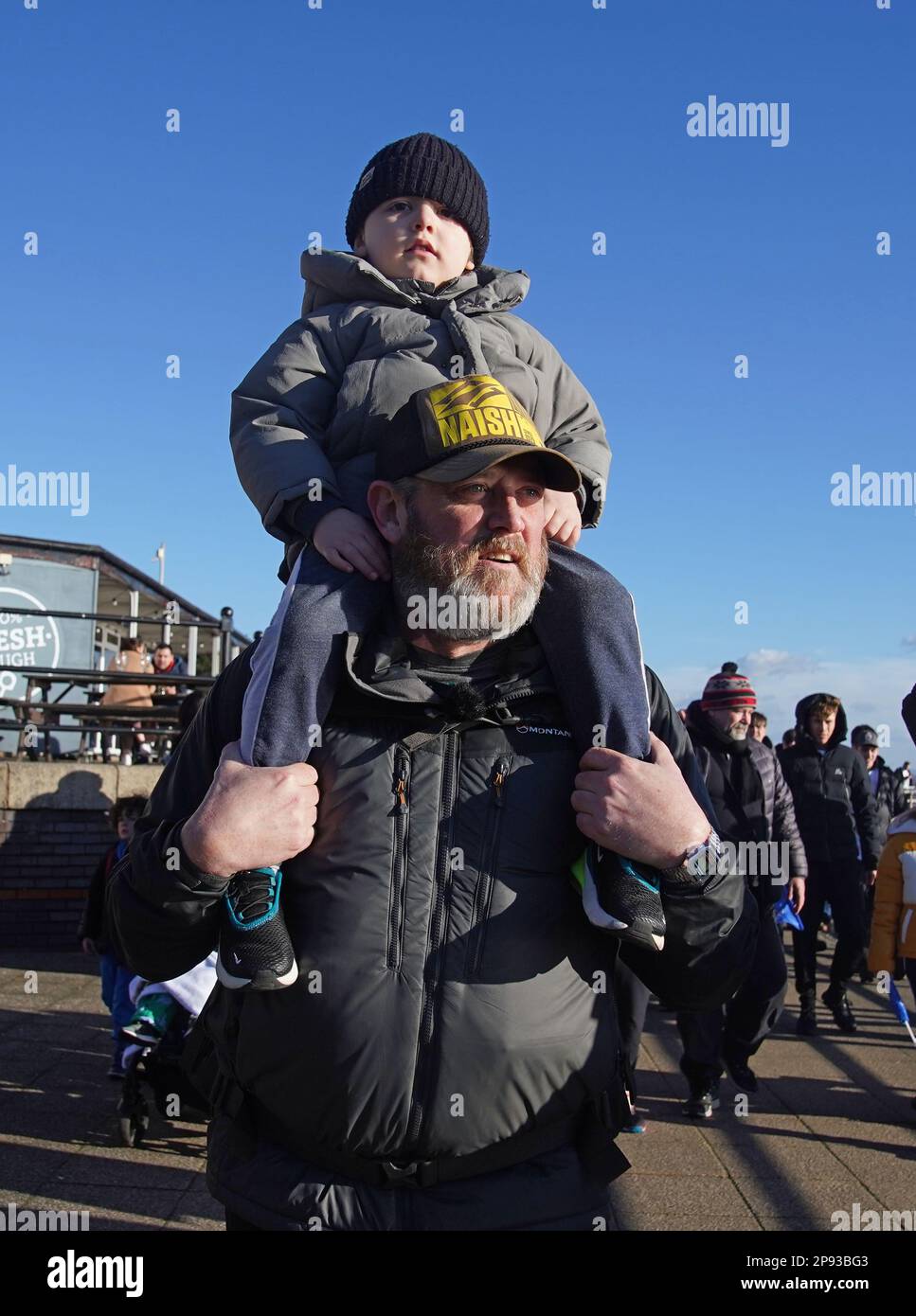 Tim Edwards, der Vater des ermordeten Elle Edwards, mit Enkel Ronan auf den Schultern in Liverpool auf einem Spaziergang von Land's End zu John O'Groats, um das Bewusstsein für das Projekt „Waffen runter Handschuhe hoch“ zu schärfen - eine Boxinitiative, die junge Menschen von der Straße in Arbeit bringen soll. Der Komiker, der am 26. Januar in Land's End begann, wurde von Herrn Edwards in Worcester begleitet, und das Paar wird die Reise gemeinsam vollenden. Foto: Freitag, 10. März 2023. Stockfoto