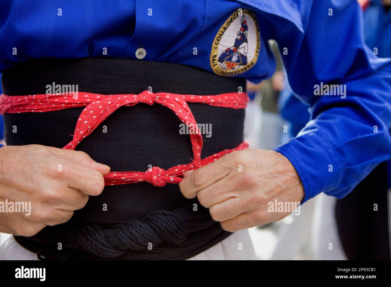 Ein Mann, der sich darauf vorbereitet, menschliche Türme zu bauen. Casors d'Esplugues.'Casors' ist eine katalanische Tradition. Festa Major del barri del Clot. Plazza Valentí Almiral Stockfoto