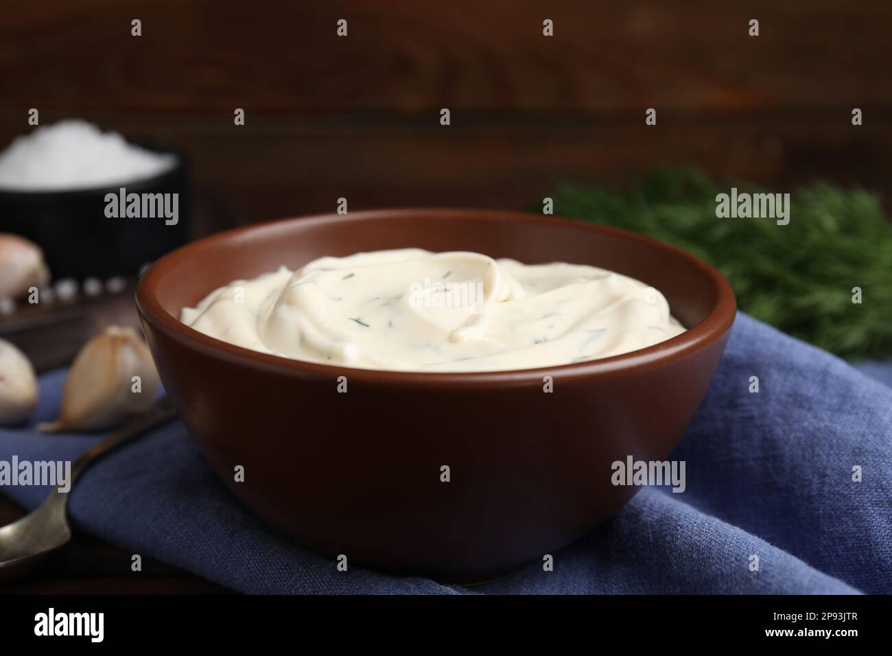 Leckere cremige Dill-Sauce in der Schüssel auf blauem Küchentuch, Nahaufnahme Stockfoto