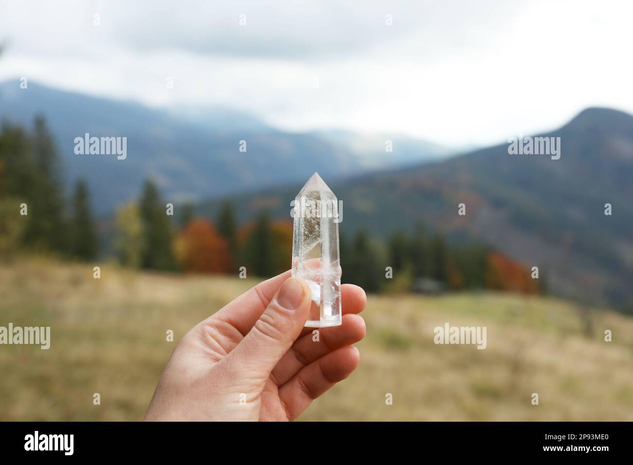 Eine Frau, die einen wunderschönen Kristall in den Bergen hält, Nahaufnahme Stockfoto