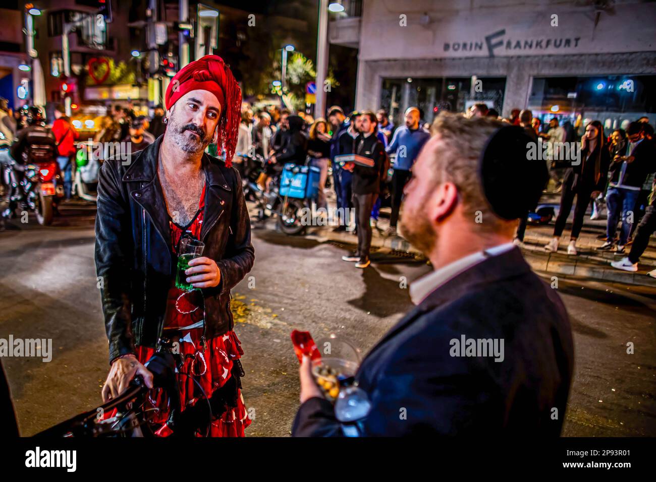 Tel Aviv, Israel. 10. März 2023. Ein Mann, der als Frau für Purim verkleidet ist, spricht mit einem orthodoxen jüdischen Mann nach einem Schussanschlag auf die Dizingof Street. Die militante palästinensische Gruppe Hamas hat sich für den Terroranschlag in Tel Aviv am Donnerstagabend verantwortlich gemacht, bei dem drei Israelis verletzt wurden. Der Angriff im Herzen der Stadt erfolgte nach einem Tag des Protests der israelischen Opposition gegen Netanjahus Regierung. (Foto: Eyal Warshavsky/SOPA Images/Sipa USA) Guthaben: SIPA USA/Alamy Live News Stockfoto