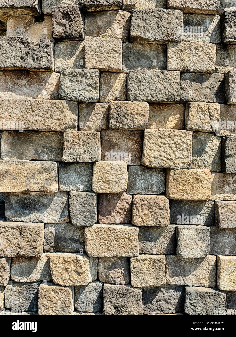 Eine Steinmauer aus Blöcken ist Teil der Gründung des buddhistischen Tempels Borobudur in der Nähe von Yogyakarta, Indonesien. Stockfoto