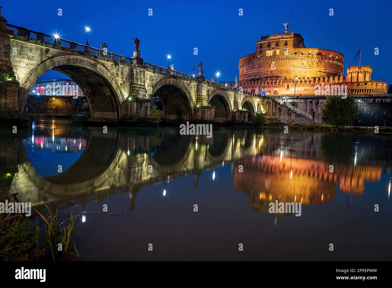 Die Brücke der Engel/Pons Aelius/Ponte Sant'Angelo mit Blick auf die Castel Sant'Angelo Cortile d'Onore o Cortile dell'Angelo bei Nacht, beleuchtet. Rom, Italien Stockfoto