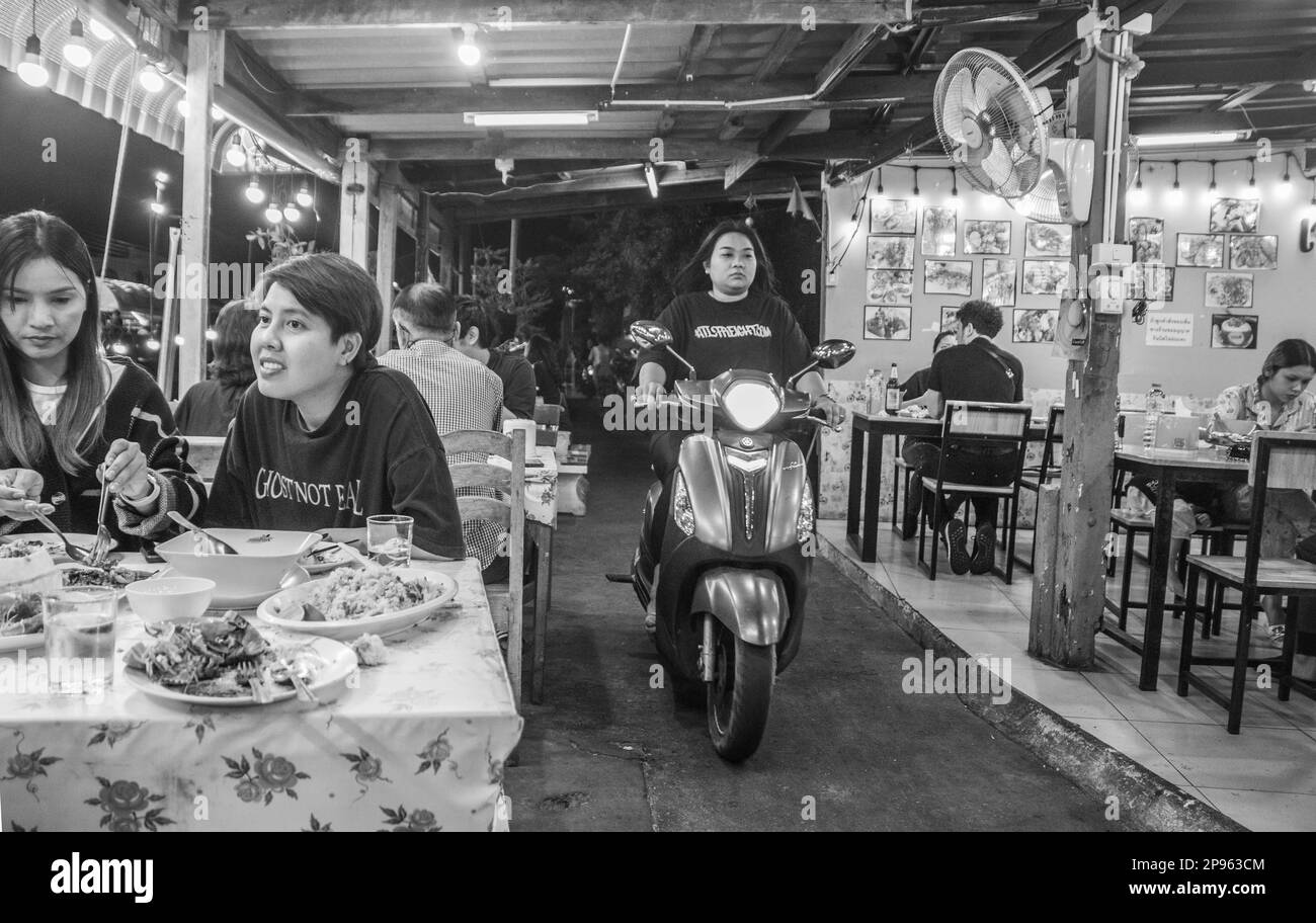 Ein traditionelles Straßenrestaurant mit einer schmalen Passage für Motorroller in Thailand, Asien Stockfoto