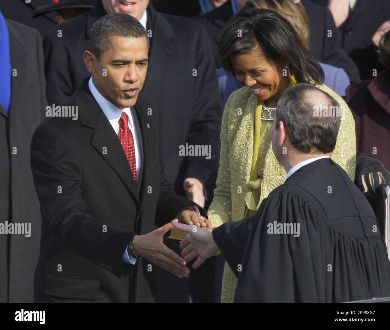 President Barack Obama, left, shakes hands with Chief Justice John Roberts after taking the oath of office at the U.S. Capitol in Washington, Tuesday, Jan. 20, 2009. At right rear is first lady Michelle Obama. (AP Photo/Elise Amendola) Stockfoto