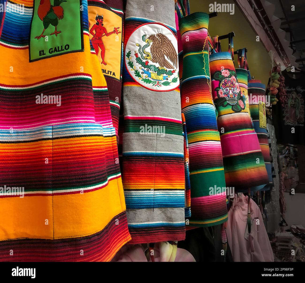 Mehrere farbenfrohe Stoffschürzen sind zum Verkauf in einem Touristenbasar mit traditionellen Artikeln aus Mexiko ausgestellt. Stockfoto
