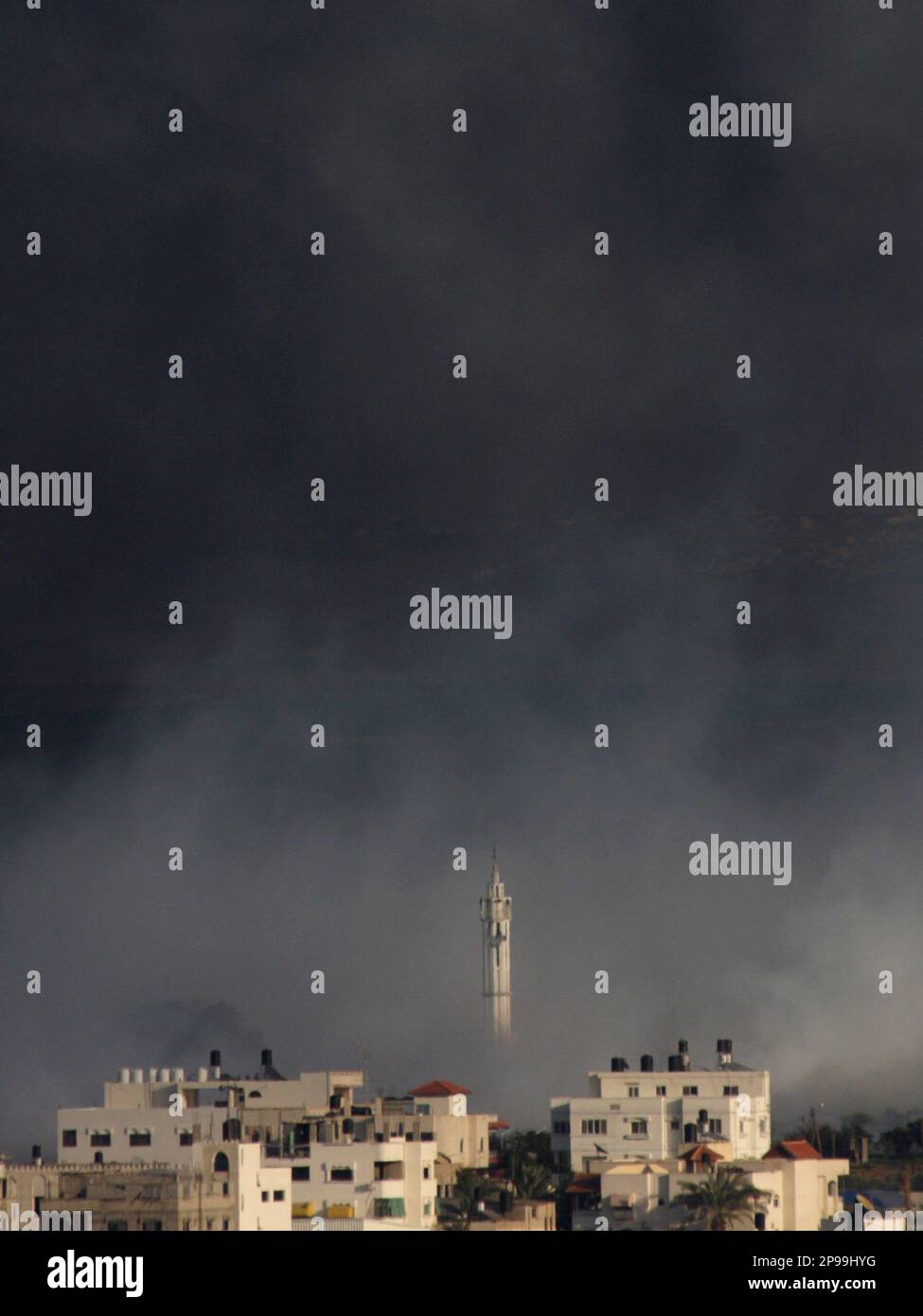 A mosque's minaret is seen though smoke caused by explosions from ...