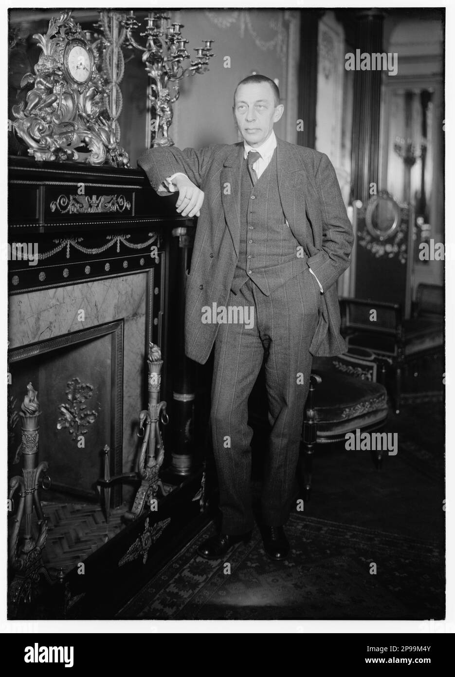 1921 , New York , USA : der russische Musikkomponist und Pianist SERGEI RACHMANINOFF ( Sergej Vasil'evic Rahmaninov - Sergej Wassiljewitsch Rachmaninov ) (Velikij Novgorod, Russland 1873 – Beverly Hills, USA 1943 ) . Er hatte großen Erfolg mit der Oper ALEKO , vier Klavierkonzerten und vielen anderen Werken . Er war einer der größten Pianisten seiner Zeit. Foto von Bain , New York - PIANISTA - COMPOSITORE - OPERA LIRICA - CLASSICA - KLASSISCH - PORTRAIT - RITRATTO - MUSICISTA - MUSICA - caminetto - CRAVATTA - TIE - - - ARCHIVIO GBB Stockfoto