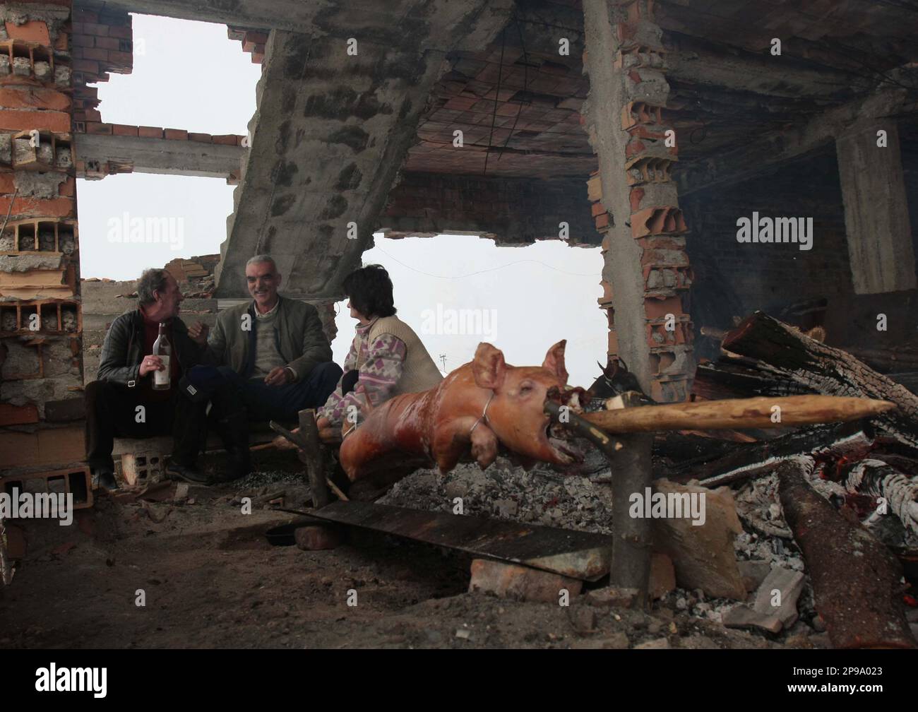 Bosnian Serbs seen near a roasted pig the traditional meal for