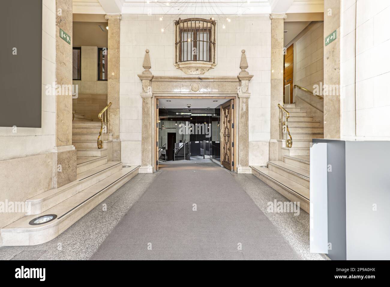 Halle eines Herrenhauses mit Treppen und dekorativen Materialien aus Marmor und Granit mit verlängertem Teppich Stockfoto