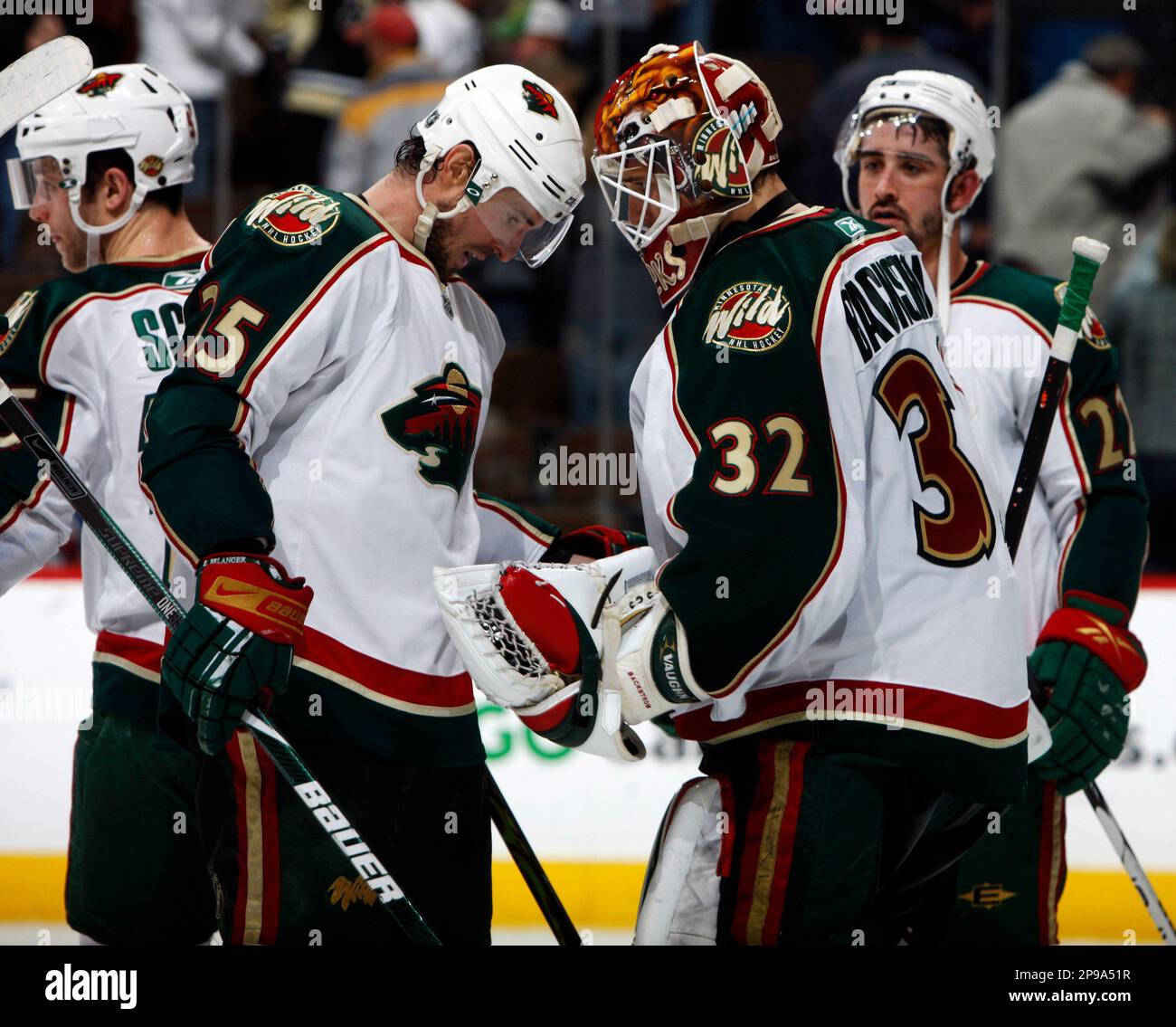 Minnesota Wild center Eric Belanger, second from left, congratulates goalie Niklas Backstrom (32), of Finland, after the Wild's 2-0 victory over the Colorado Avalanche in an NHL hockey game in Denver on Sunday, Jan. 4, 2009. (AP Photo/David Zalubowski) Stockfoto
