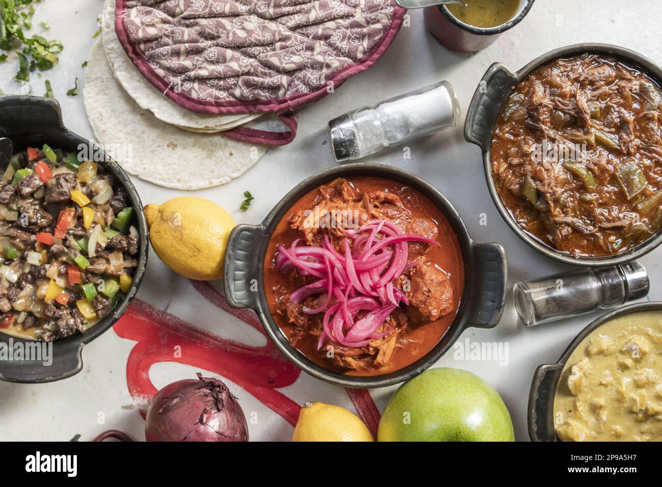 Mexikanisches Speisenrezept mit Cochinita Pibil Eintopf, Rinderalamabre, viel Obst, Saucen und Weizentortillas Stockfoto