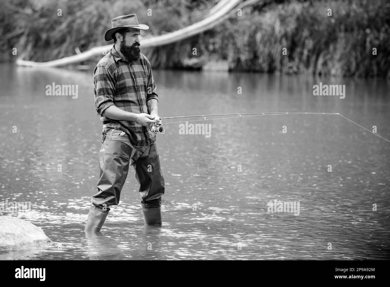 Schwerer bärtiger Fischer im Wasser. Reifer Mann, Fliegenfischen. Angeln macht Spaß. Wirkliches Glück. Bärtiger Fischer. Mit Inspiration gestalten. Mann beim Angeln. Stockfoto