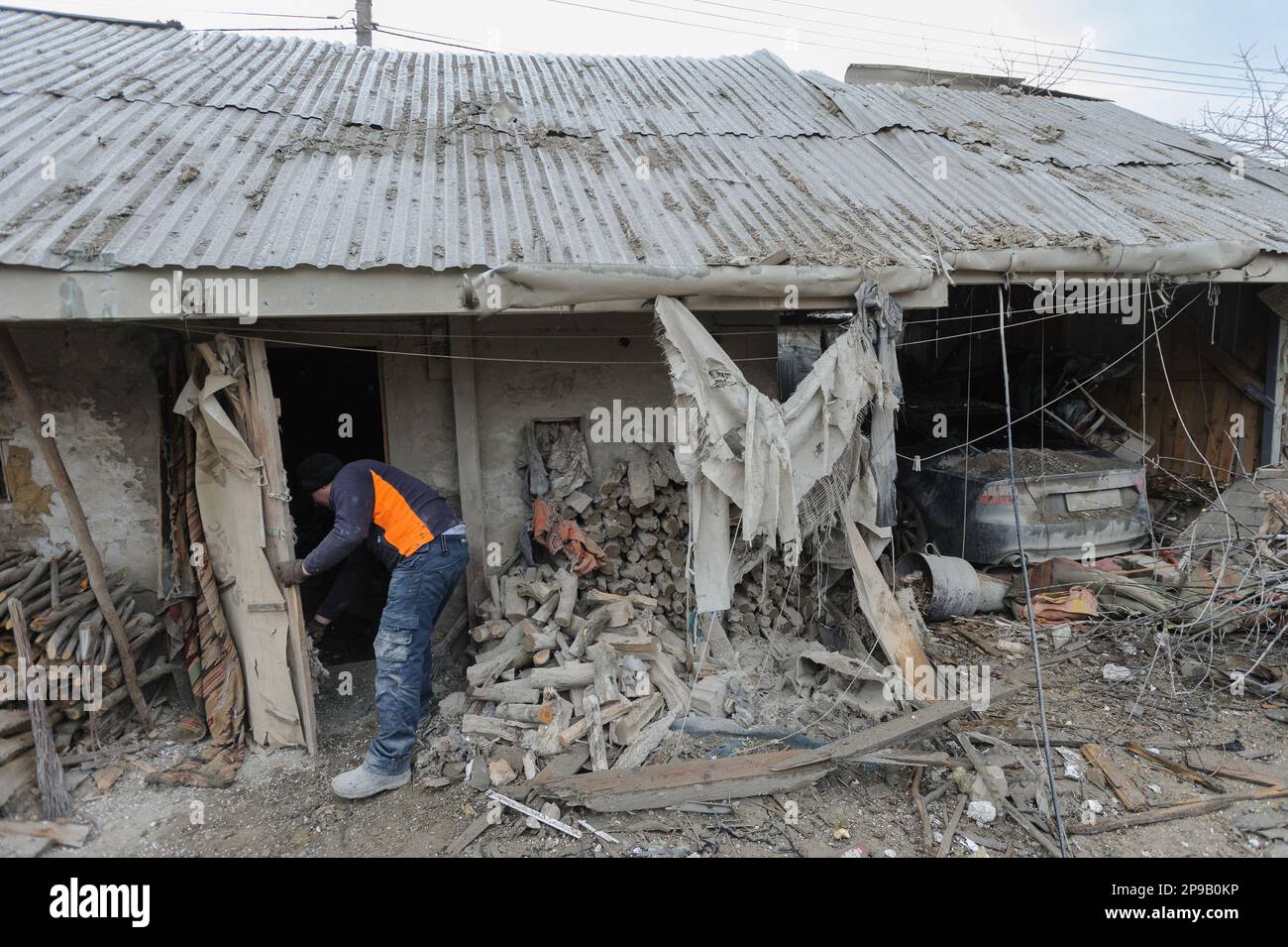 Der Mann überprüft sein Privathaus, das bei Russlands nächtlichen Raketenangriffen in einem Dorf im Bezirk Zolochiv in der Region Lemberg ruiniert wurde. Russland greift weiterhin die Energieinfrastruktur der Ukraine an. Stockfoto