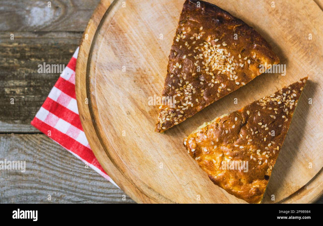 Hausgemachter Kuchen mit Sesamsamen und rudistiger Kruste auf Holzhintergrund. Hausgemachtes Backen Stockfoto