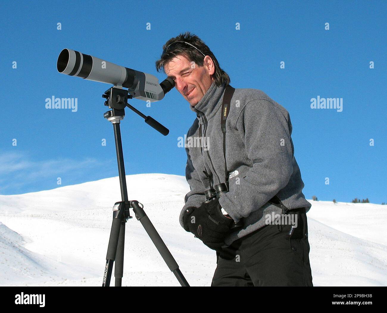 Simond Raymond peers through a spotting scope in the Lamar Valley of Yellowstone National Park