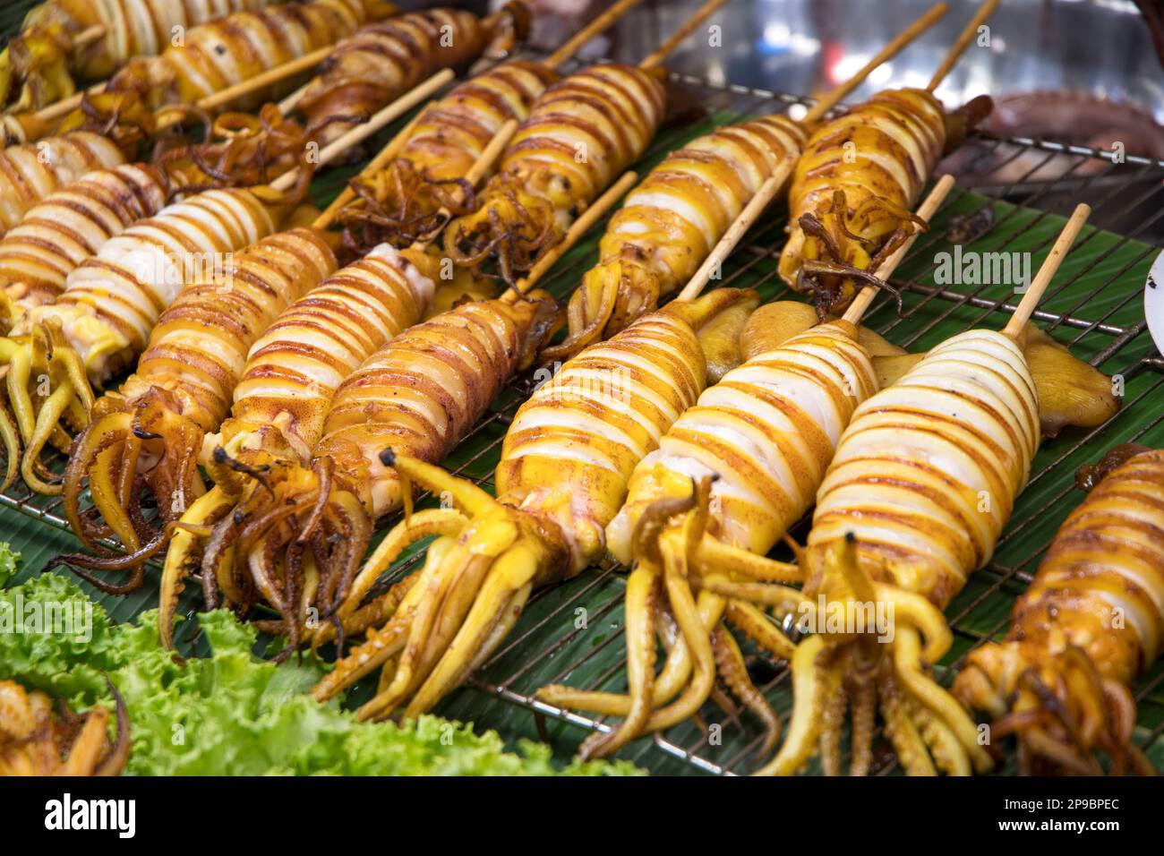 Gegrillter Tintenfisch auf Spießen auf dem Straßenmarkt von Bangkok, Thailand Stockfoto