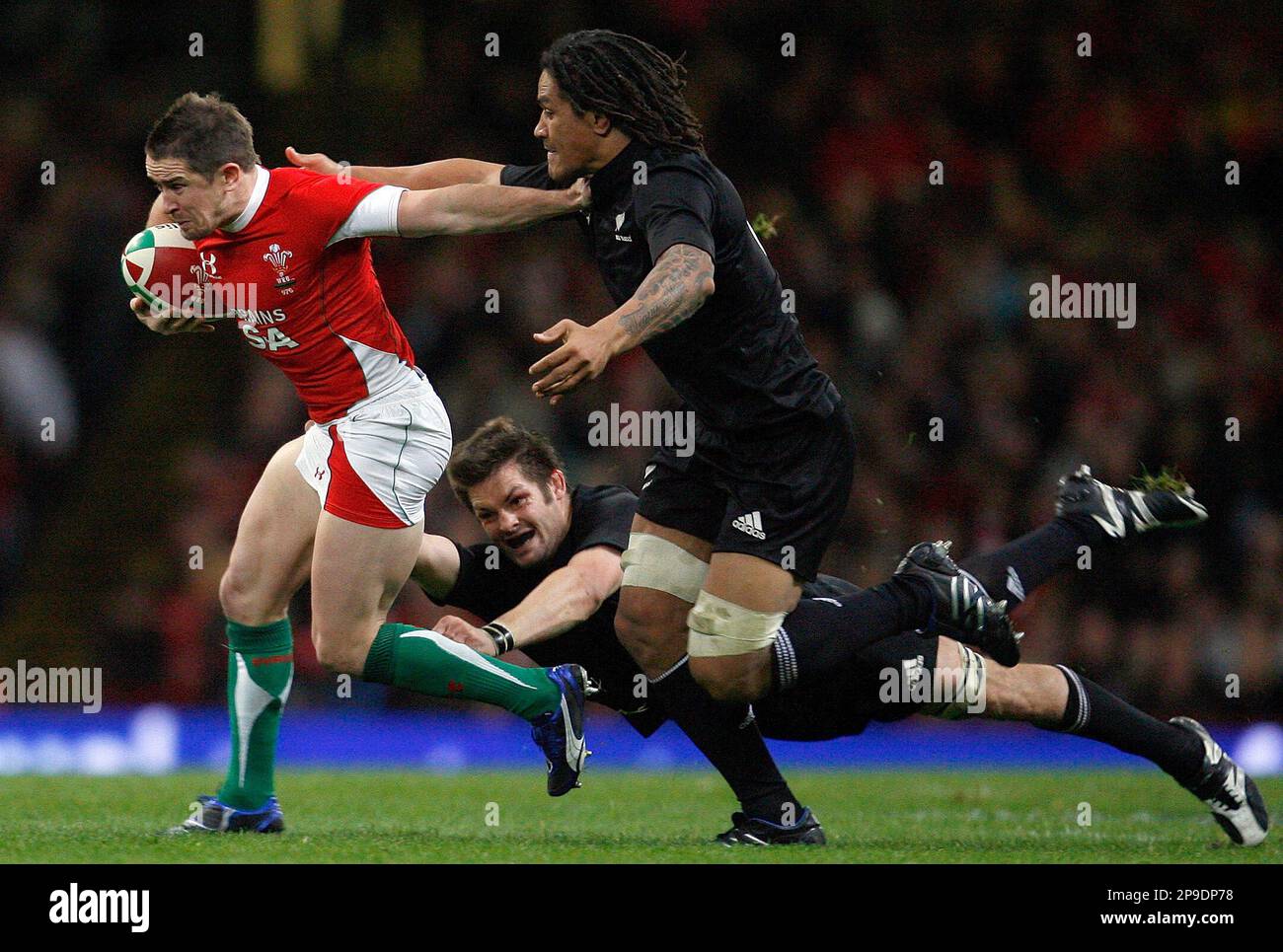 Wales's Shane Williams, left, is tackled by New Zealand's Richie McCaw, ground and Rodney So'oialo during the international rugby match between Wales and New Zealand at the Millennium Stadium in Cardiff, Wales, Saturday, Nov. 22, 2008. (AP Photo/Paul Thomas) Stockfoto