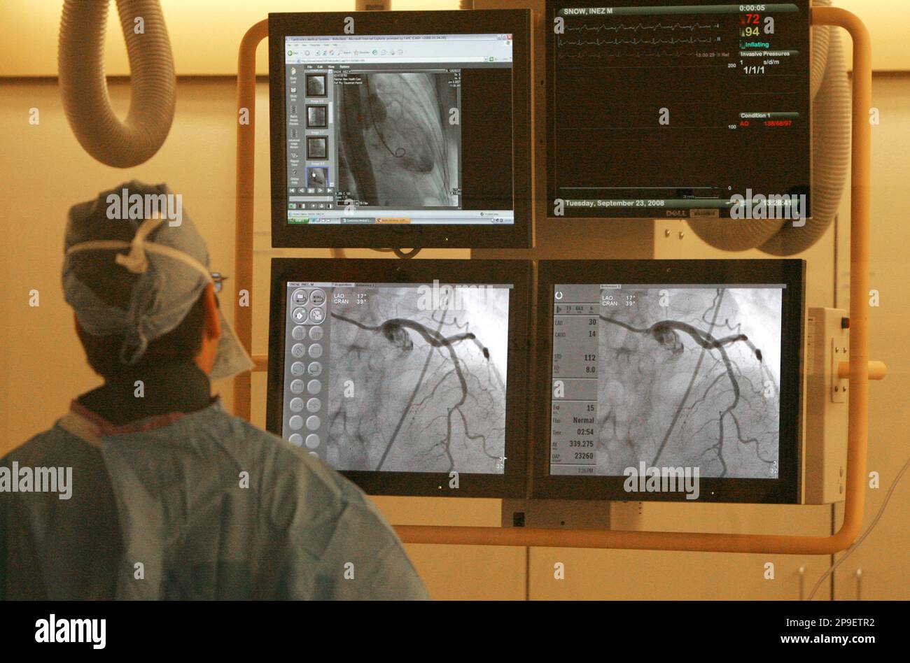 **APN ADVANCE FOR SUNDAY NOV. 16** Dr. Harold Dauerman checks monitors during a catheterization lab heart procedure in Burlington, Vt., Tuesday, Sept. 23, 2008. Heart specialists at Fletcher Allen Health Care have developed a cutting-edge method to get heart attack victims treated fast, by delegating decisions to colleagues in remote hospitals and, in some cases, with specially-equipped ambulances. (AP Photo/Toby Talbot) Stockfoto
