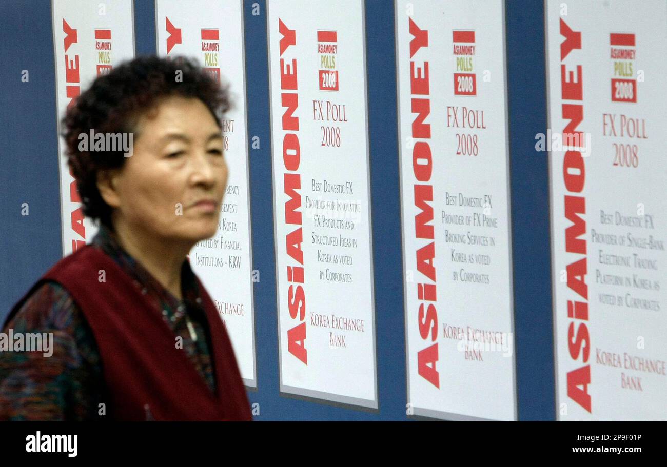 A South Korean elderly woman walks past a bank's ad banners in downtown Seoul, South Korea, Monday, Nov. 10, 2008. Fitch Ratings on Monday lowered the sovereign credit rating outlooks for six emerging market economies to reflect possible increased burdens stemming from the global credit crisis and slowing economy. (AP Photo/Lee Jin-man) Stockfoto
