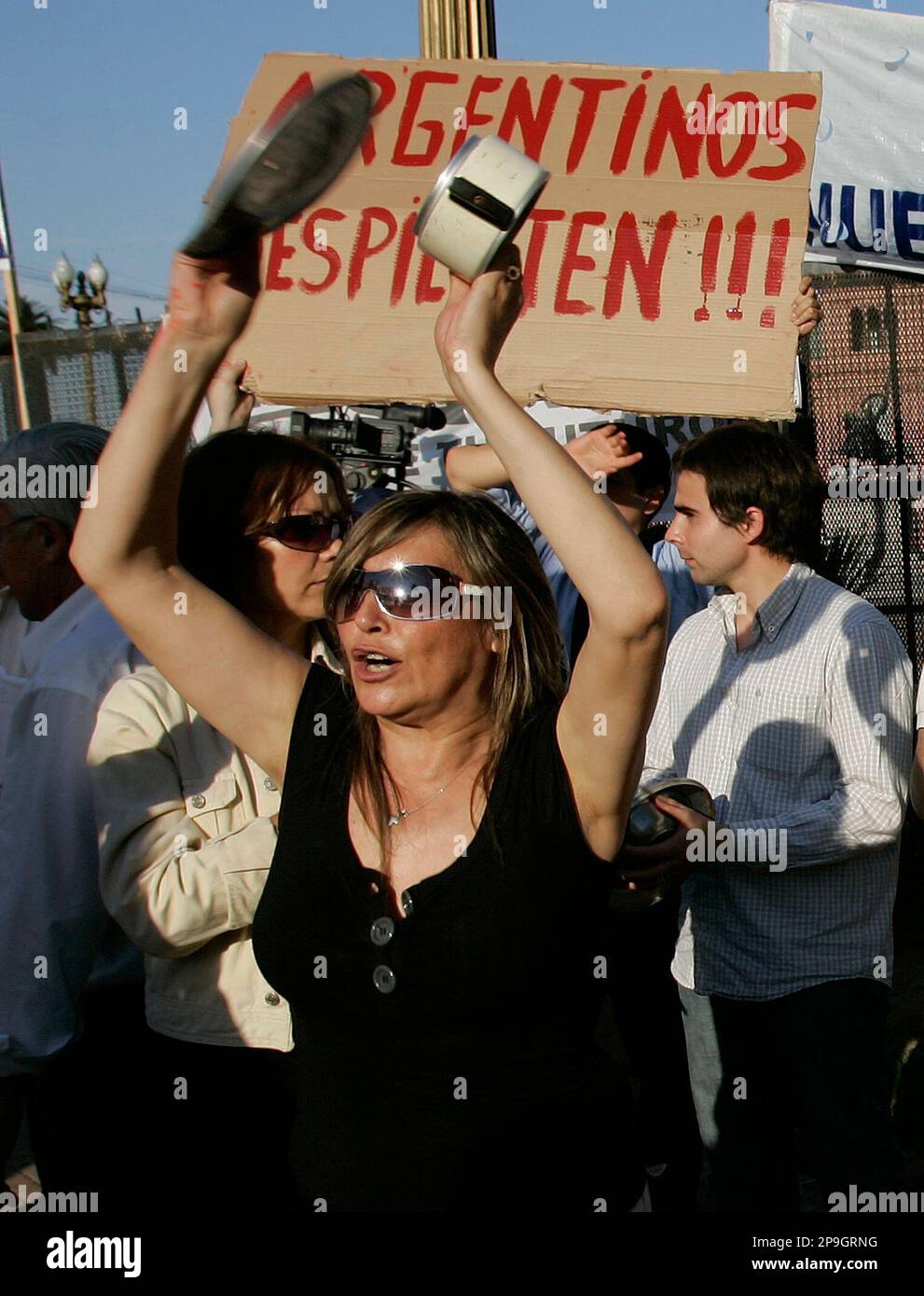An employee of a private pension company, holding up a sign that reads in Spanish "Argentines wake up," bangs cans during a protest in Buenos Aires, Thursday, Oct. 23, 2008. Argentina's President Cristina Fernandez proposed a government takeover of nearly US$30 billion in private pension funds, saying retirees must be protected from the global financial crisis. (AP Photo/Eduardo Di Baia) Stockfoto