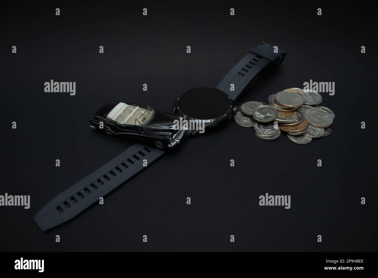Konzept für Wohlstand und Finanzplanung. Ein Foto von einem Auto, einer Smartwatch und einem Haufen Münzen, nach einigen Änderungen. Stockfoto