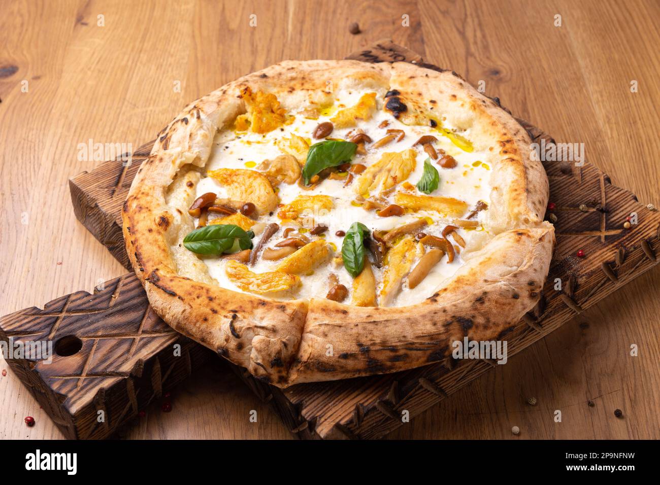 Pizza Polo mit Mozzarella-Käse, Hühnerfilet, eingelegtem Honigtau, Basilikum und Olivenöl. Im Ofen gebackene Pizza mit knuspriger Kruste. Stockfoto