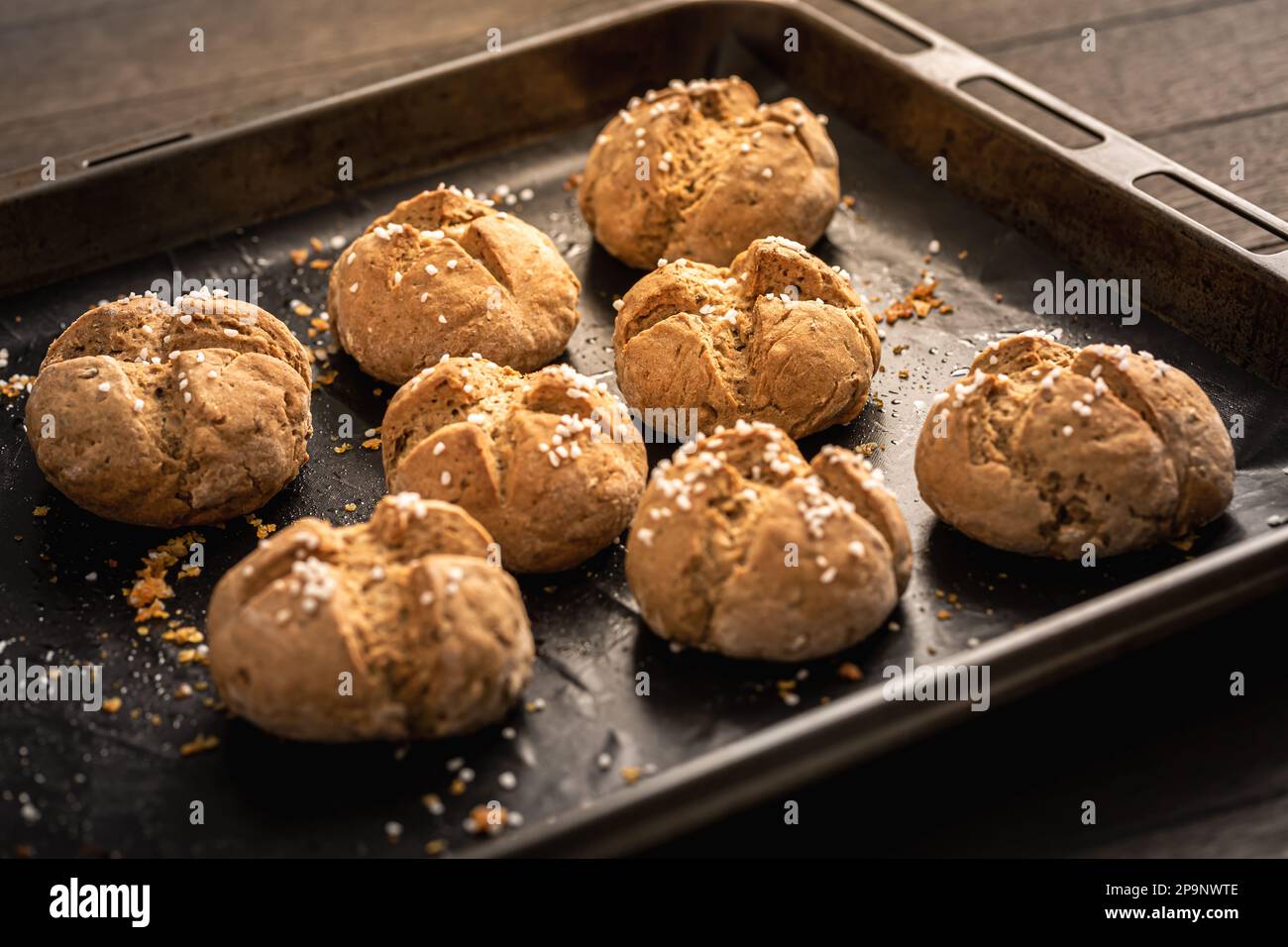 Hausgemachte Dinkelbrötchen mit Salz auf Backpapier Stockfoto