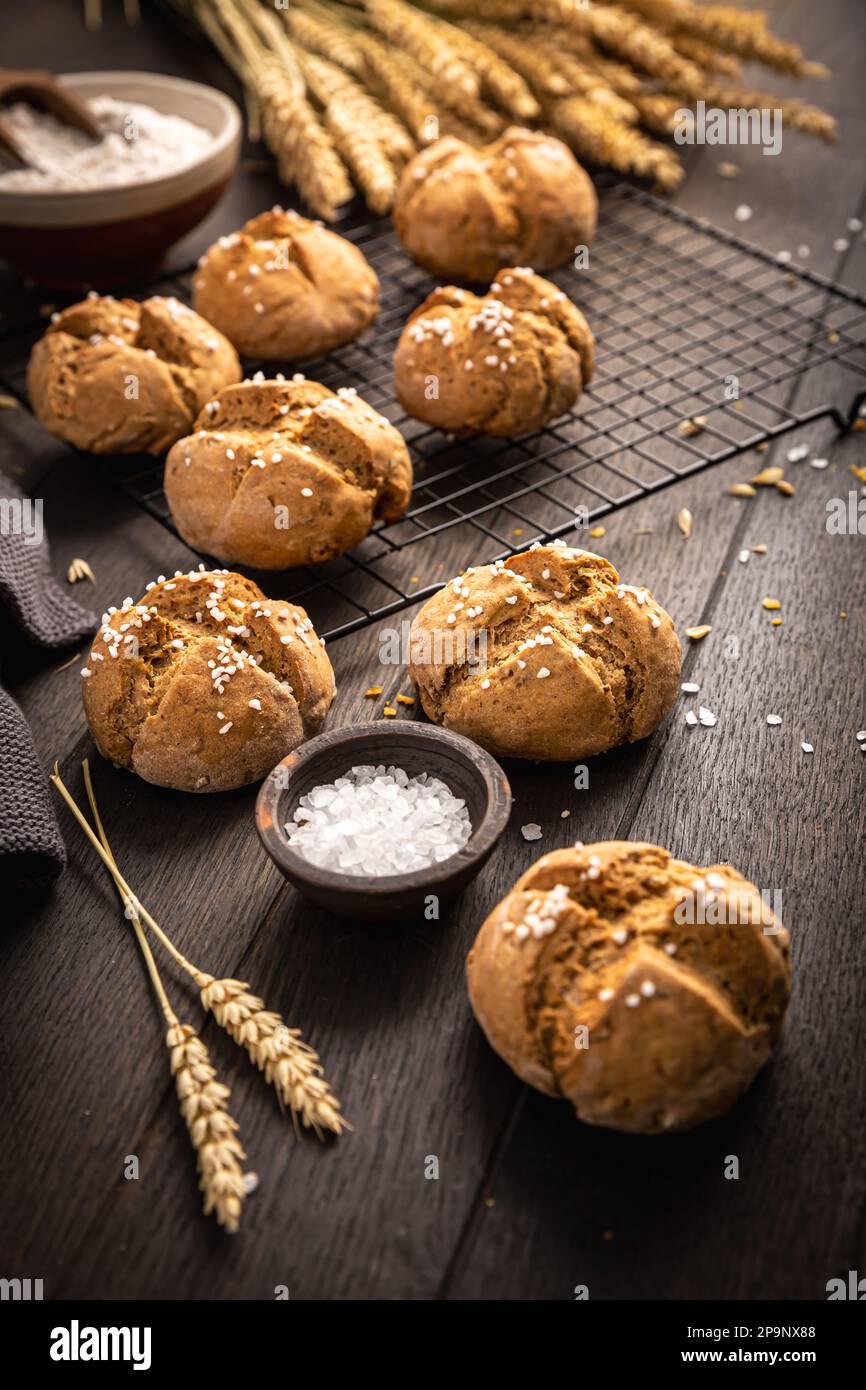 Hausgemachte Spelzbrötchen mit Salz auf Holzhintergrund Stockfoto