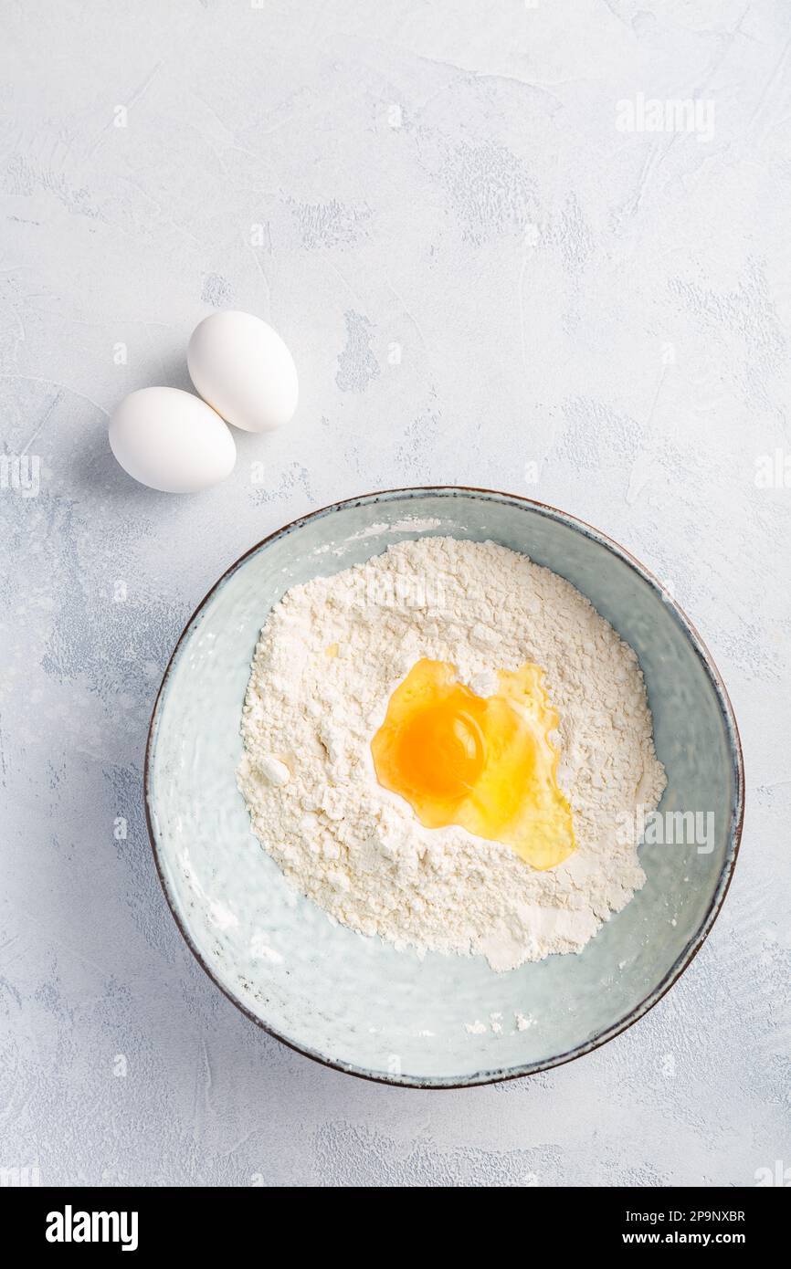 Mehl mit Ei in der Schüssel – Koch- und Backzutaten Stockfoto