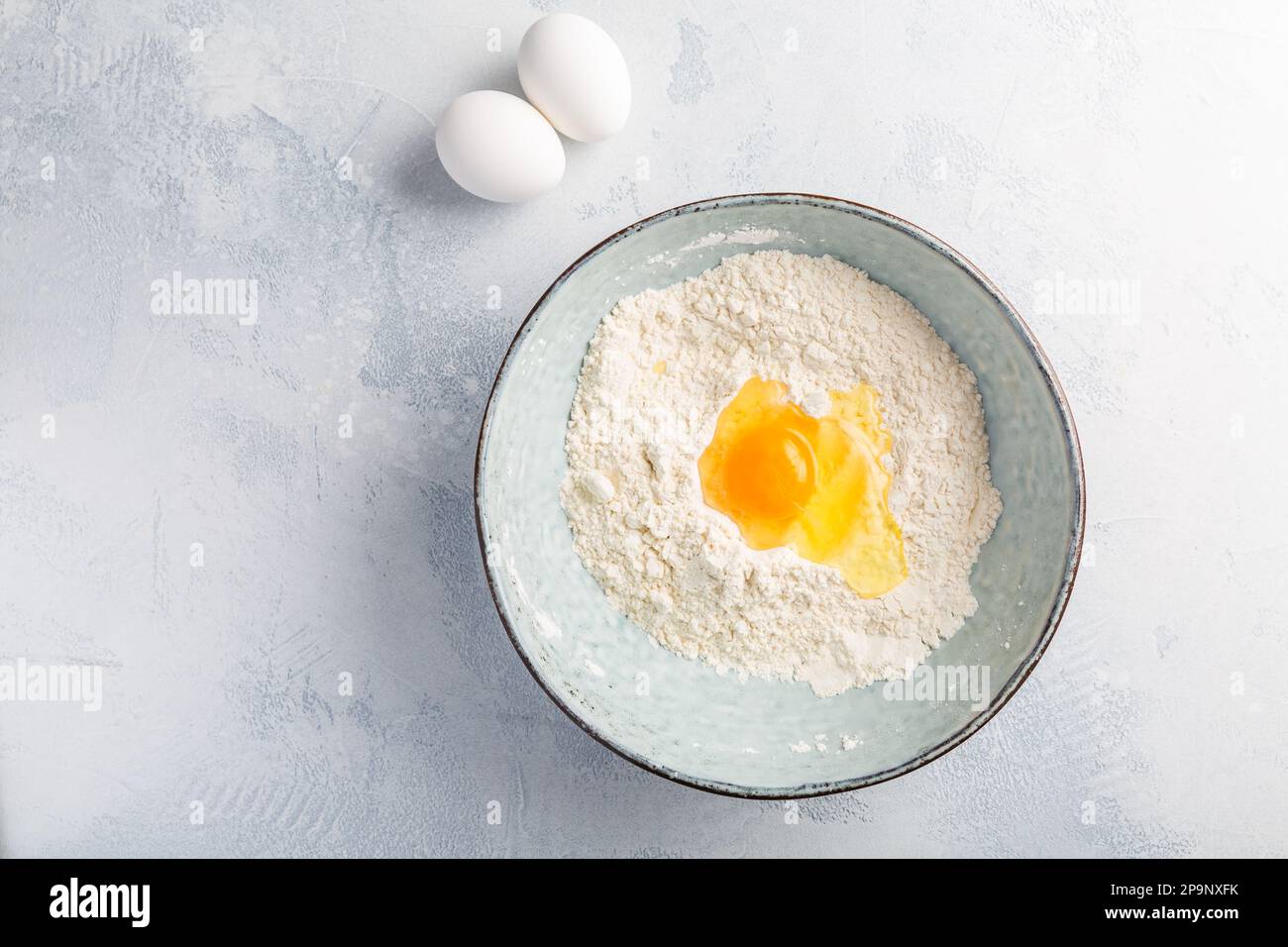 Mehl mit Ei in der Schüssel – Koch- und Backzutaten Stockfoto