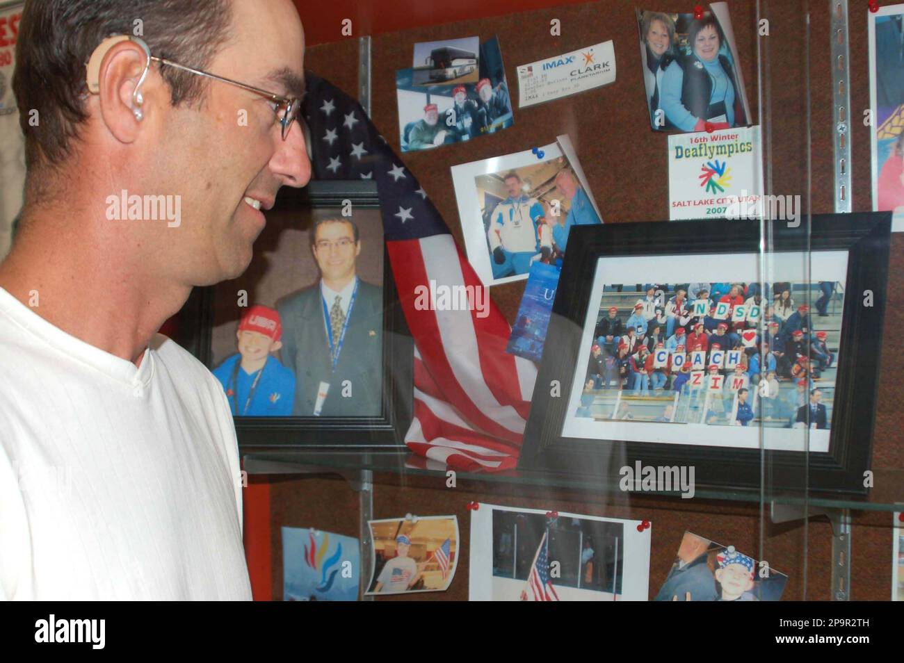 ** ADVANCE FOR WEEKEND, AUG 23-24 ** Devils Lake High School hockey coach David Zimmerman looks at a display from the 2007 Deaf Olympics, when Zimmerman was an assistant coach for the gold medal-winning U.S. team, Aug. 5, 2008, in Devils Lake, N.D. Zimmerman is deaf, but can communicate with hearing aids and lip reading. The display is at the North Dakota School for the Deaf, where Zimmerman teaches. (AP Photo/Dave Kolpack) Stockfoto