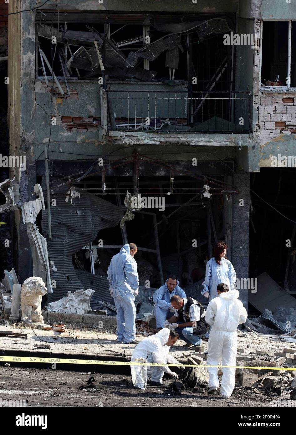 Turkish police forensics officers investigate the site after a car explosion that injured at least 13 people, mostly police officers, in western Turkish city of Izmir, Turkey, Thursday, Aug. 21, 2008, media reports said citing local officials.The blast, set off by remote control, occurred near a bus carrying police officers , private NTV television and state-run Anatolia news agency said.(AP Photo) Stockfoto