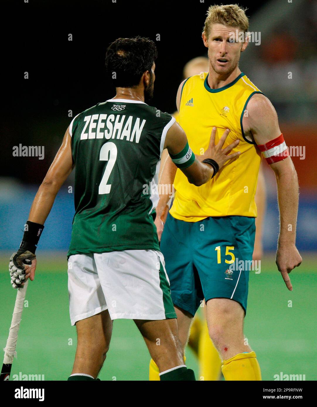 Australia's captain Bevan George, right, is restrained by Pakistan's Zeeshan Ashraf during the field hockey competition at the Olympic Hockey Center at the Beijing 2008 Olympics in Beijing, Friday, Aug. 15, 2008. Australia won 3-1. (AP Photo/Rick Rycroft) Stockfoto