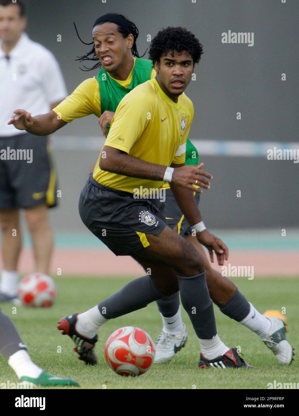 Brazil's Ronaldinho, left, battles for the ball with teammate Breno during a training session in Shenyang, China, Friday, Aug. 15, 2008. Brazil will face Cameroon in a Beijing 2008 Olympics quarterfinal round men's soccer match on Saturday, Aug. 16. (AP Photo/Roberto Candia) Stockfoto