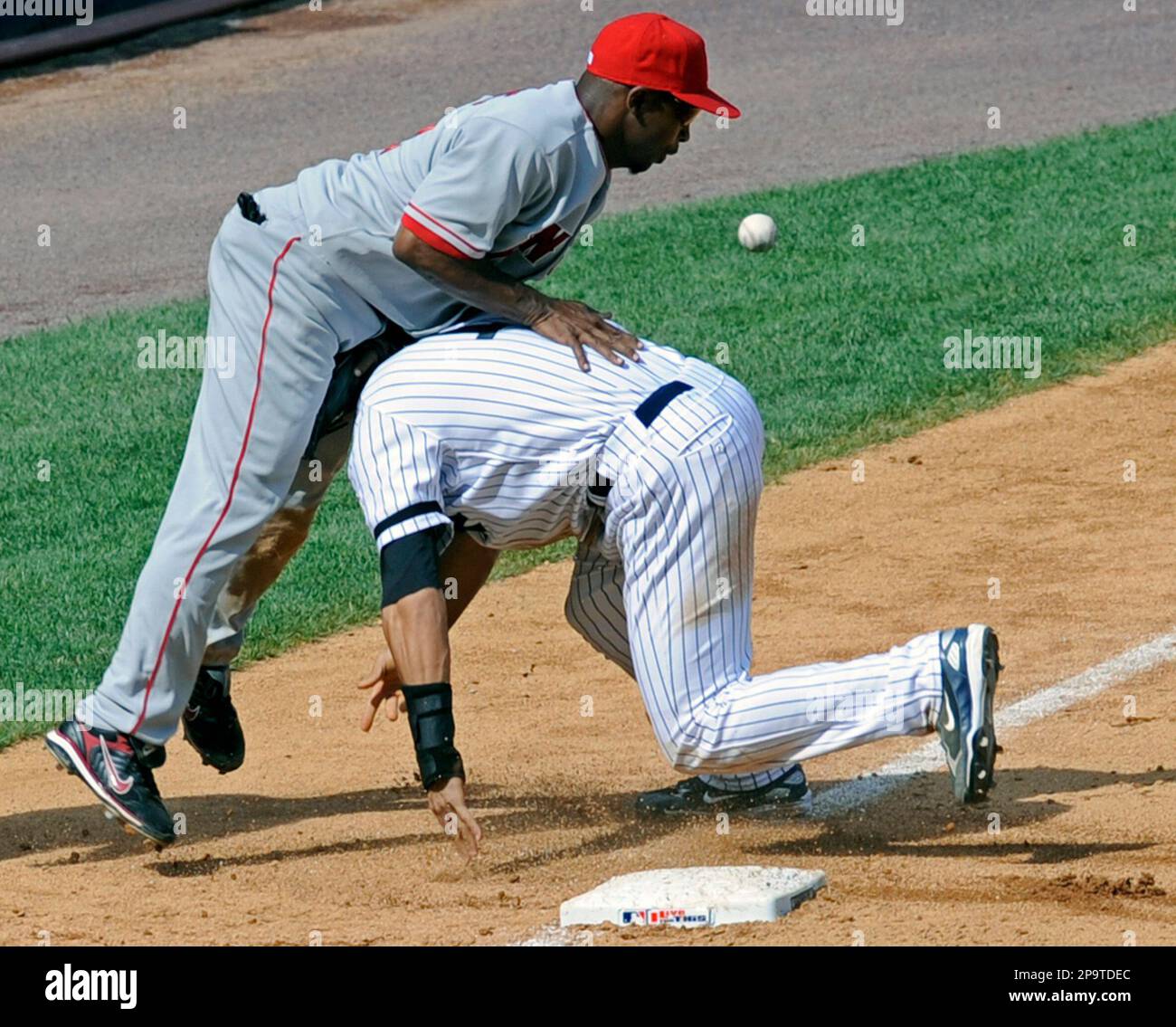 New York Yankees' Justin Christian attempts to run home as the ball gets away from Los Angeles Angels third baseman Chone Figgins during the eighth inning of a baseball game Sunday, Aug. 3, 2008 at Yankee Stadium in New York. Christian stole third base and scored on the error. (AP Photo/Bill Kostroun) Stockfoto
