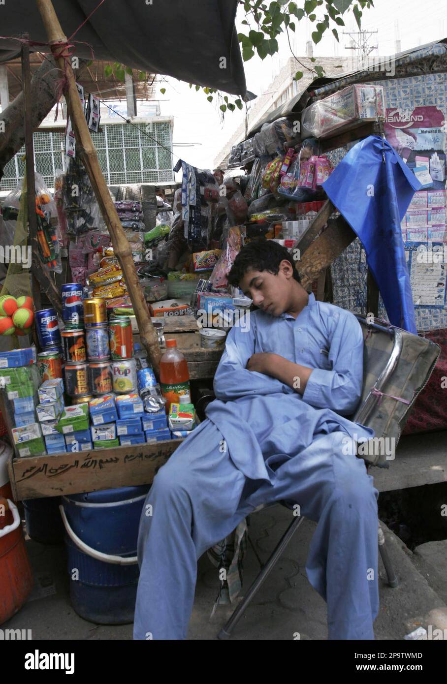 A young Afghan street vendor takes a nap, as he waits for customers in the city of Jalalabad, the provincial capital of Nangarhar province east of Kabul, Afghanistan on Tuesday, July 29, 2008. (AP Photo/Rahmat Gul) Stockfoto