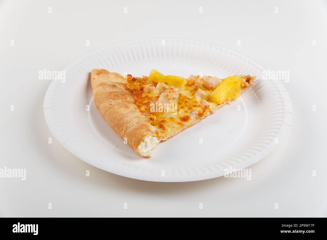 Ein Stück hawaiianische Pizza mit Huhn und Ananas mit Käseplatte auf Papierteller isoliert auf weißem Hintergrund. Stockfoto